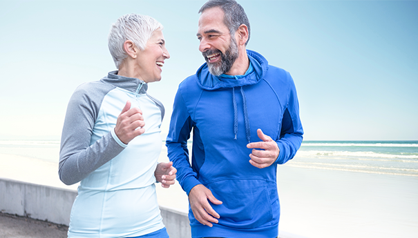 Older couple running outside in training gear